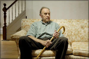 Lonely, elderly man sitting on a couch.